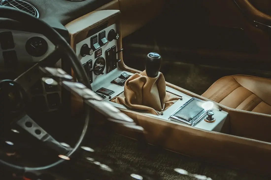 Tan leather seats and console inside a dimly lit car cabin